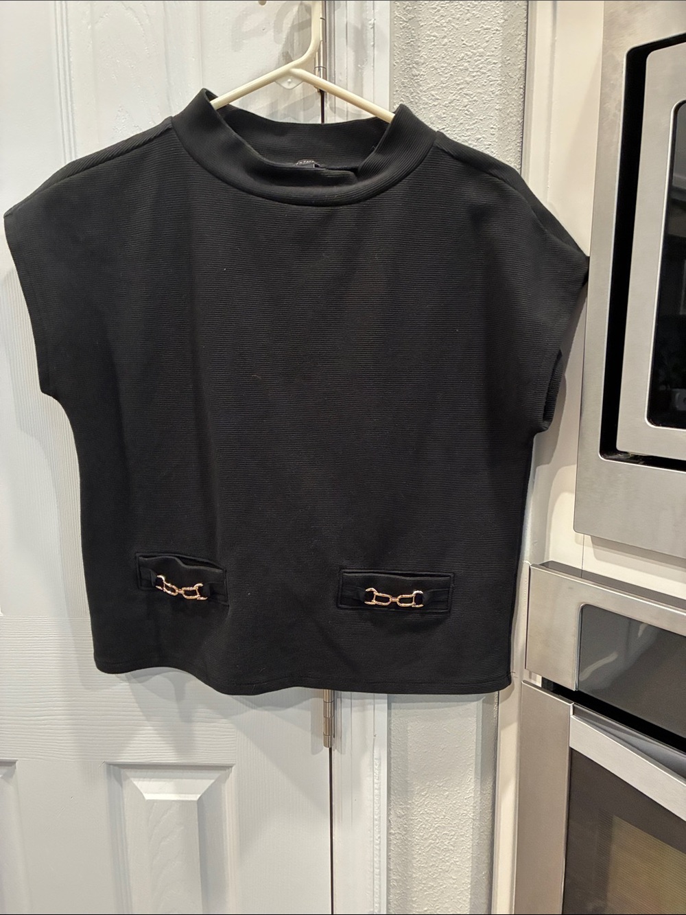 Womenโs Black Sleeveless Mock-Neck Top with Gold Accent